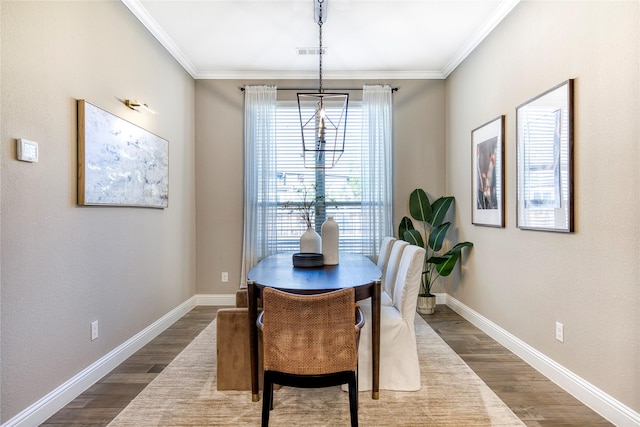 dining room with dark wood-style floors, visible vents, crown molding, and baseboards