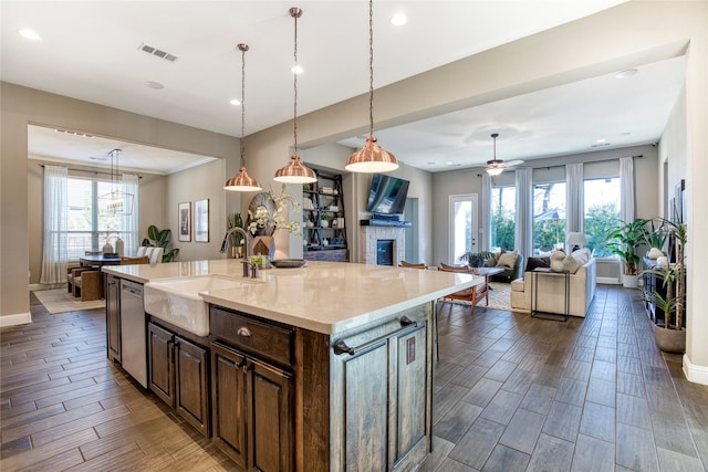 kitchen featuring dishwasher, wood finish floors, a sink, and visible vents