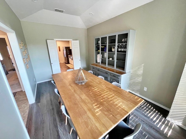 dining area with lofted ceiling, wood finished floors, visible vents, and baseboards