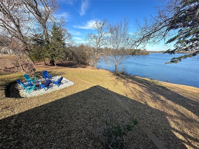 view of yard featuring a water view, a fire pit, and a patio area