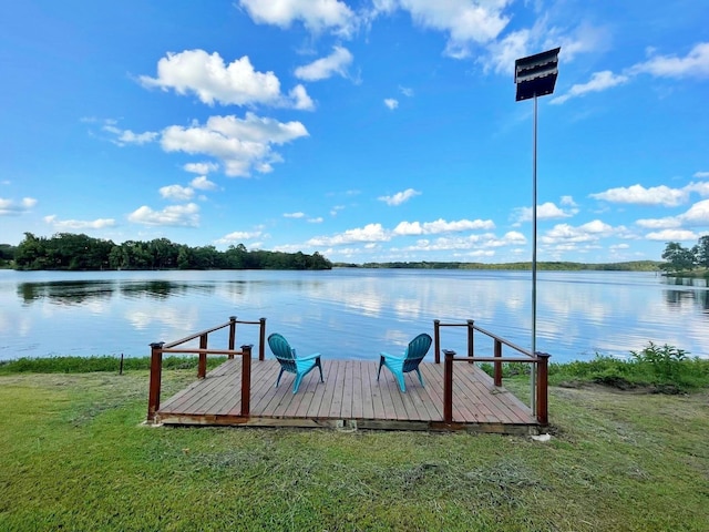 dock area with a lawn and a water view