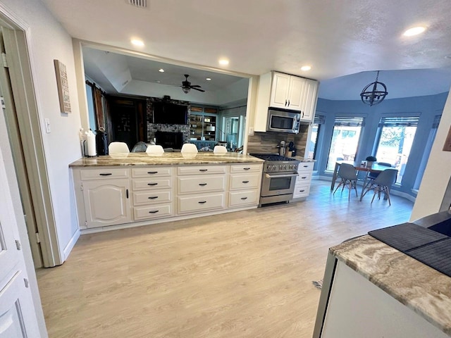 kitchen with light wood finished floors, recessed lighting, backsplash, appliances with stainless steel finishes, and white cabinets