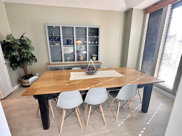 dining area with baseboards, wood finished floors, and a healthy amount of sunlight