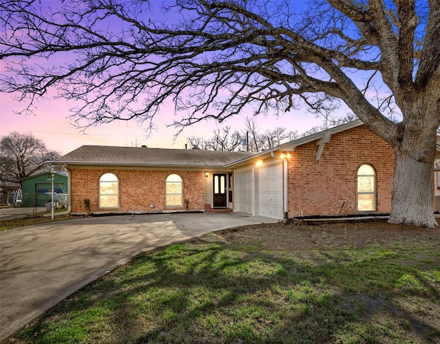 view of front facade featuring a garage, driveway, and brick siding