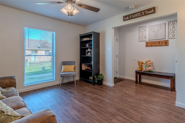 sitting room featuring a ceiling fan, baseboards, and wood finished floors