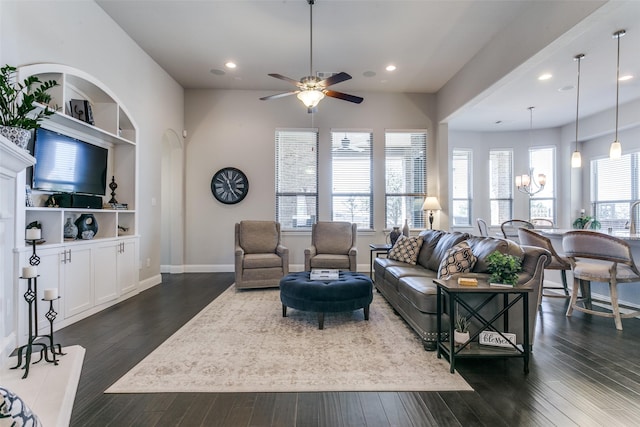 living room featuring a healthy amount of sunlight, baseboards, and dark wood-style flooring