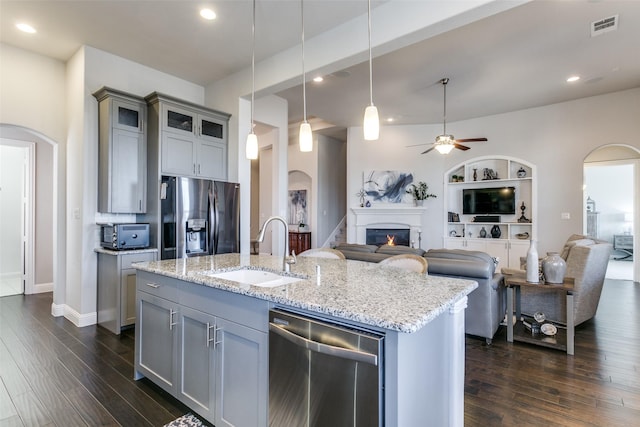 kitchen with arched walkways, gray cabinets, visible vents, appliances with stainless steel finishes, and a sink