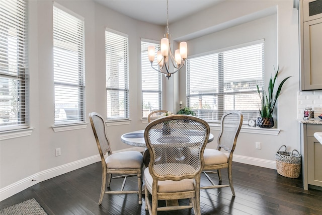 dining space featuring a healthy amount of sunlight, a chandelier, and dark wood-type flooring