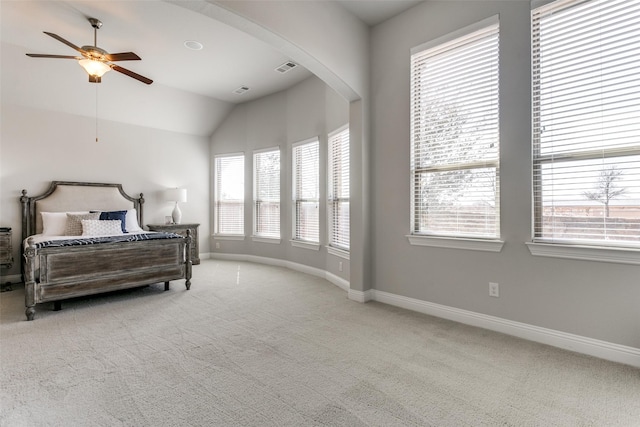 carpeted bedroom with a ceiling fan, lofted ceiling, arched walkways, and baseboards