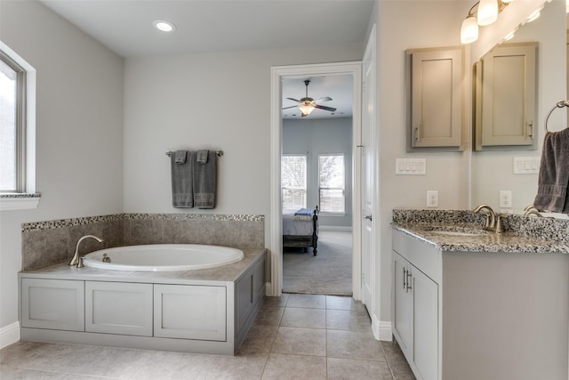 ensuite bathroom with baseboards, ensuite bath, tile patterned floors, a garden tub, and vanity