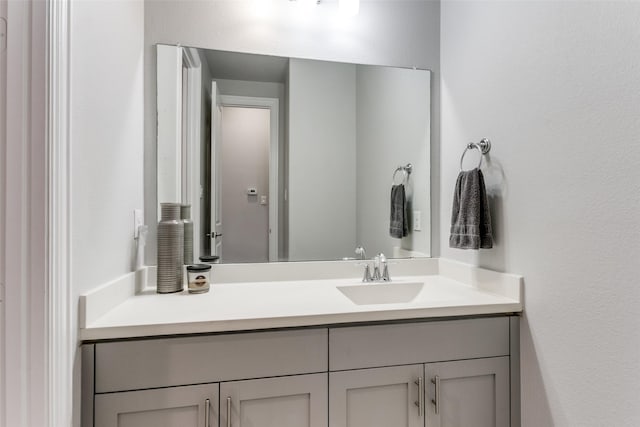 bathroom with a textured wall and vanity