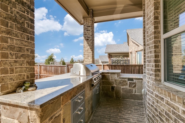 view of patio with fence, grilling area, and exterior kitchen