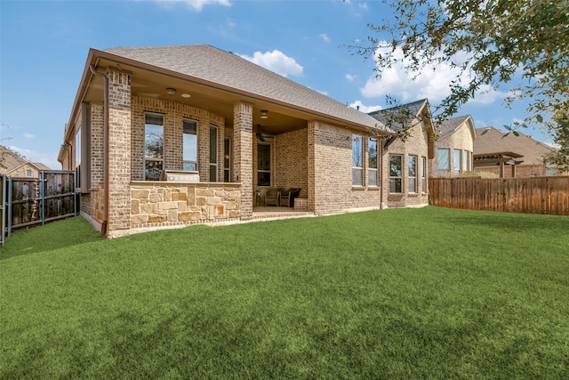 back of property featuring a yard, brick siding, a patio area, and a fenced backyard