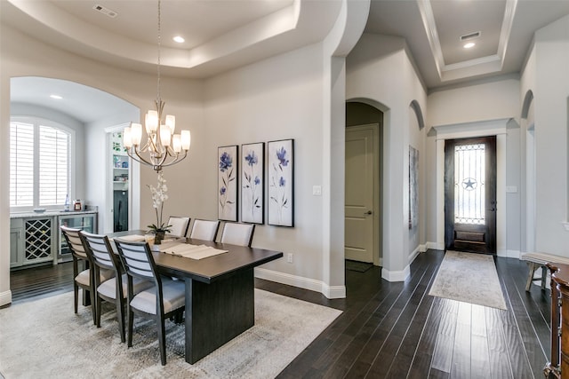 dining space with baseboards, a raised ceiling, and dark wood-type flooring