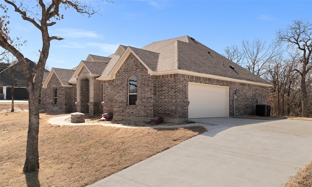 view of home's exterior featuring a garage, driveway, brick siding, and roof with shingles