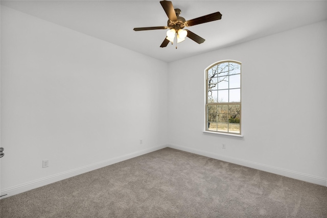 spare room with carpet floors, a ceiling fan, and baseboards