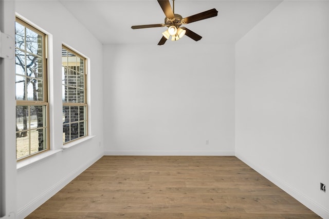 spare room with ceiling fan, wood finished floors, and baseboards