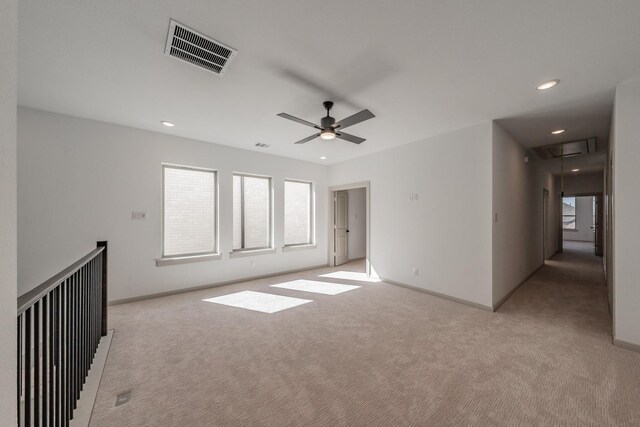 spare room with recessed lighting, attic access, visible vents, and light colored carpet