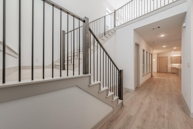 staircase with baseboards, visible vents, wood finished floors, and recessed lighting