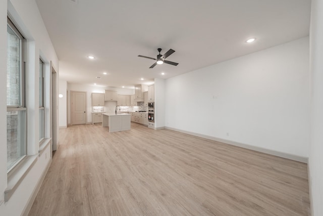 unfurnished living room featuring light wood-type flooring, ceiling fan, baseboards, and recessed lighting