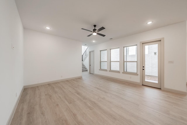 empty room with stairway, light wood-type flooring, and recessed lighting