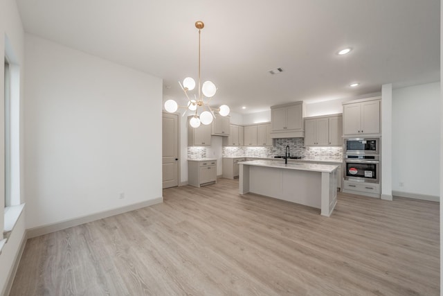 kitchen featuring visible vents, decorative backsplash, appliances with stainless steel finishes, light wood-style floors, and a sink