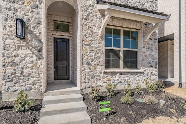 doorway to property with stone siding