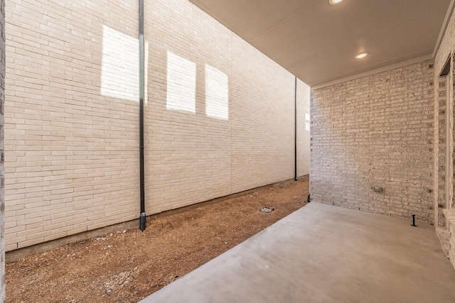 interior space featuring concrete flooring, brick wall, and recessed lighting