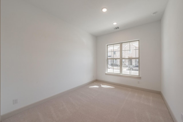 spare room featuring recessed lighting, carpet flooring, visible vents, and baseboards