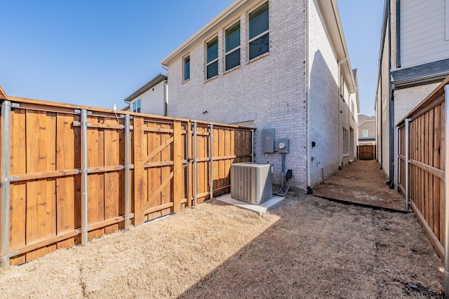 back of property featuring central AC and brick siding