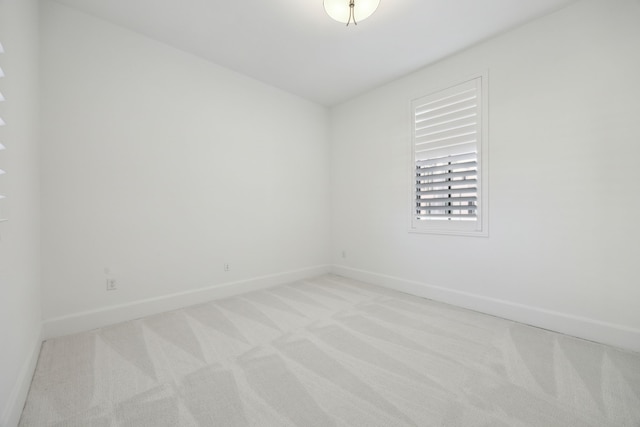 empty room with baseboards and light colored carpet