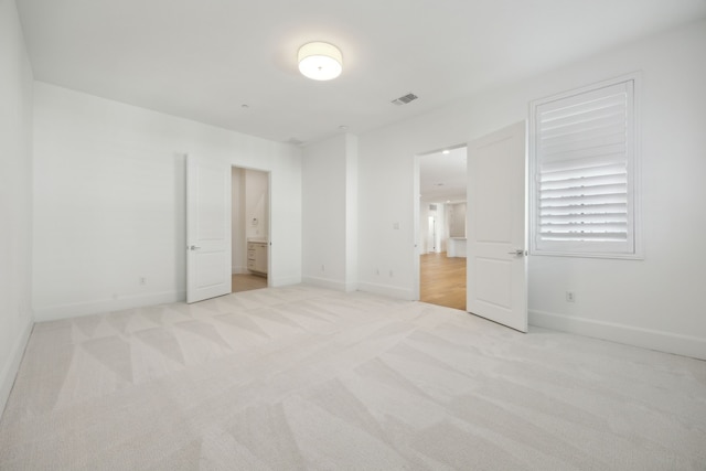 unfurnished bedroom featuring baseboards and light colored carpet