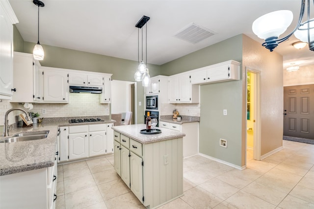 kitchen with visible vents, under cabinet range hood, black appliances, white cabinetry, and a sink