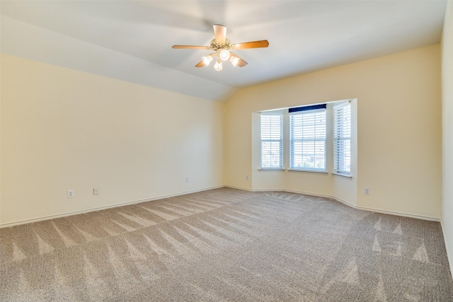 empty room with ceiling fan, baseboards, vaulted ceiling, and light colored carpet