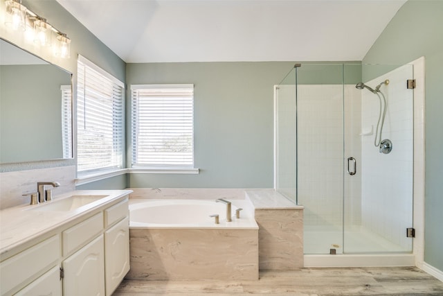 bathroom with lofted ceiling, a garden tub, wood finished floors, vanity, and a shower stall