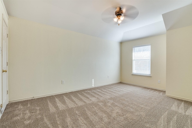 unfurnished room featuring lofted ceiling, baseboards, a ceiling fan, and light colored carpet