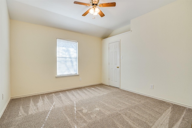 empty room with lofted ceiling, baseboards, a ceiling fan, and carpet flooring