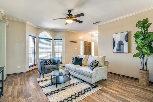 living room featuring wood finished floors, visible vents, and crown molding