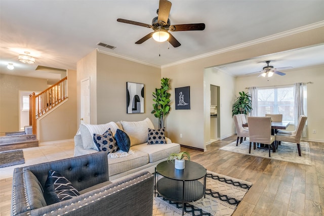 living area featuring light wood-style floors, visible vents, stairway, and baseboards