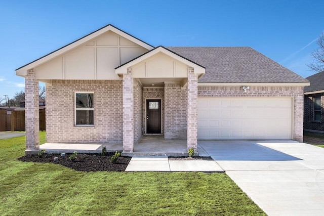 view of front of house with brick siding, roof with shingles, concrete driveway, an attached garage, and a front yard