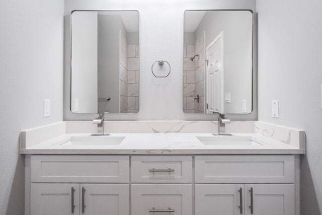 full bathroom featuring walk in shower, a sink, and double vanity