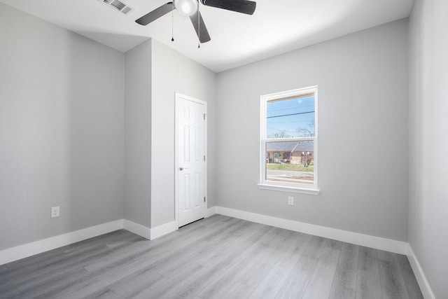 unfurnished bedroom featuring baseboards, visible vents, ceiling fan, and light wood finished floors