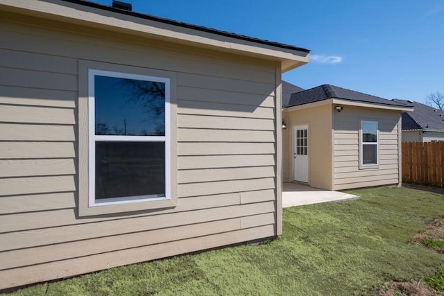 view of side of property featuring fence and a lawn