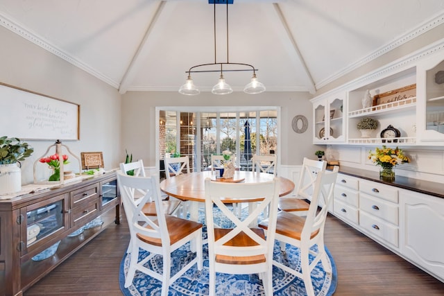 dining room with a wainscoted wall, vaulted ceiling, ornamental molding, and dark wood finished floors