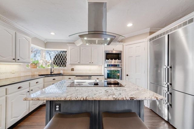 kitchen featuring stainless steel appliances, a sink, white cabinets, decorative backsplash, and island exhaust hood