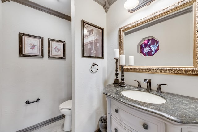 bathroom featuring toilet, crown molding, and vanity