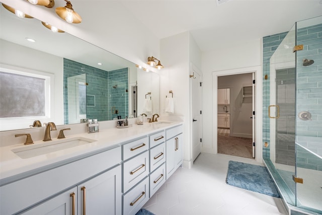 full bath with a stall shower, a sink, a spacious closet, and double vanity