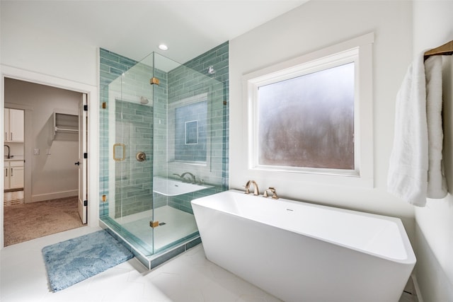 bathroom featuring tile patterned flooring, recessed lighting, a spacious closet, a soaking tub, and a shower stall