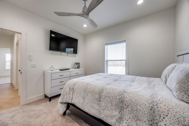 bedroom with light carpet, multiple windows, baseboards, and recessed lighting