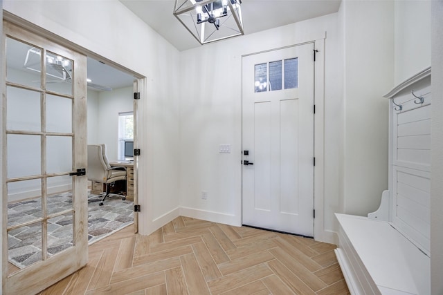 entrance foyer with a chandelier and baseboards